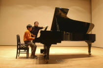 11 year old boy named Satoshi Ui plays at a piano recital