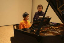 11 year old boy named Satoshi Ui plays the piano at his recital
