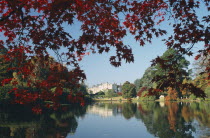 Informal landscape garden initially laid out by Capability Brown in the 18th Century.  View across lake to house framed by trees in Autumn colours.