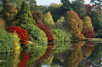 Informal landscape garden initially laid out by Capability Brown in the 18th Century.  Trees in Autumn colours reflected in lake.
