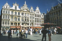 Grand Place lined with cafes with crowds of people and stalls.