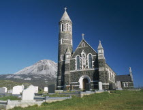 Roman Catholic church and graveyard with Errigal peak of the Derryveagh Mountain Range behindEire Republic Ireland