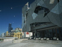 Federation Square modern facades with the Flinders Street railway station and Rialto Tower beyond