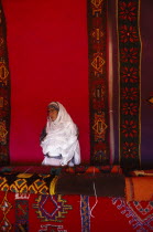 Woman with traditional carpets.