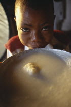 Young boy next to bowl of breakfast at the Kititimo Centre School for street chldren. Center