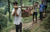 Patient being carried in cloth stretcher.