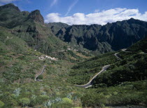 Masca.  Winding road through valley with housing on terraced lower slopes and steep cliffs above.