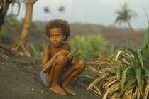Tanna Island.  Ni Vanuatu child sitting on volcanic sand.