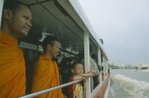 Buddhist monks and other passengers on the Chao Phrya River express.