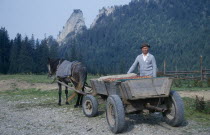 Farmer with horse drawn wooden cart.