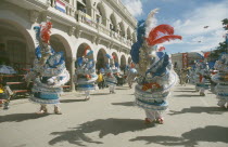 Carnival masqueraders in colourful animal costumes in a street lined with colonial buildingsColorful