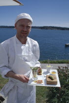 Magnus Ech owner and chef holding a tray of food at Oaxen Skargards Krog restaurant