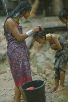 Karen Longneck tribe woman washing young girls hair