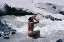 Pilgrim bathing in snow melted water at Gormuich the Cows Mouth one of the sources of the Ganges