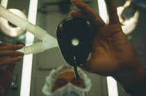 View looking up toward anaesthetist holding face mask from a patients perspective