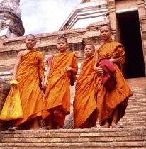 Four novice monks standing on temple steps