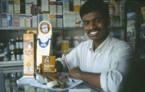 Male chemist displaying condoms.