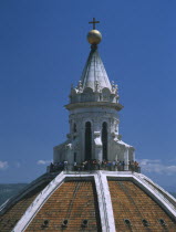 The Duomo.  Apex of the Dome by Brunelleschi with tourists encircling spire.  Taken from the Campanile.
