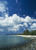 Pantai Cenang beach looking towards Gunung Mat Cincang with a stoney beach in the foreground