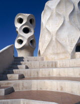 La Pedrera.  Gaudi architecture  carved chimney pots and curved steps on the rooftop.