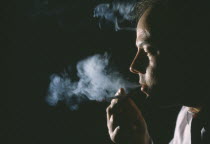 Man exhaling smoke from cigarette.