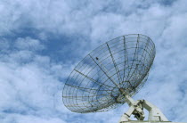 Satellite dish with a light clouded sky behind
