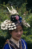 Miao girl in traditional costume and headress with silver decoration.  Head and shoulders portrait. Asia Asian Chinese Chungkuo Jhongguo Zhonggu Classic Classical Historical Jhonggu Older
