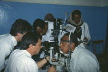 Man leaning his head on a rest having an Orbis Eye Examination