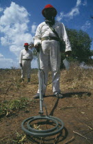 Mine Clearance workers holding metal detector.