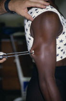 Man measuring female athletes body fat on her arm