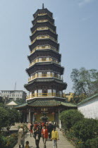 Octagonal Flower Pagoda within the compound of the Temple of the Six Banyan Trees.  Exterior view with people on the pathway outside.