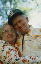 Elderly couple embracing.