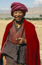 Tibetan Buddhist Monk by the Yellow River holding prayer beads