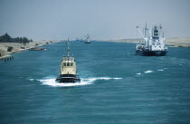 Looking down Canal with tug approaching and ships moving away