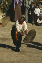 Dancer beating a hide drum at a festival