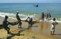 Fishermen hauling seine net ashore on west coast beach.Ocean fishingOcean fishing