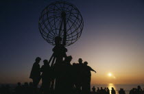 The North Cape globe sculpture with tourists watching the midnight sun