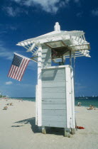 Lifeguard tower on beach with American Stars and Stripes flag.