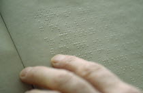 Close up of hand reading braille