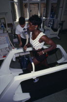 VO2 MAX Endurance Testing. Female athlete wearing breathing equipment and running on a treadmill with coach at her side