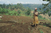 Burundian returnee from Rwanda cultivating land using fertilizer supplied by the EEC.