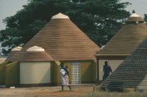 Women and child outside new village housing.