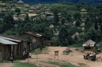 Village huts scattered over hillside amongst trees and vegetation. Zaire