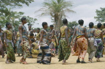 Female dancers wearing colourful textiles at festival and watching crowd behind.Colorful Zaire