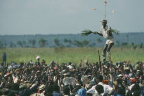 Stilt walker above crowds at Bapende tribe Gungu Festival. Pende