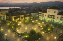 Parque Cespedes at night.  Elevated view over paved square and surrounding buildings with people and street lights.