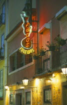Illuminated neon sign in the Bairro Alto advertising Fado a musical genre especially popular in Lisbon.