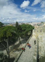 Tourist visitors on fortified walls of Castelo de Sao Jorge  with city stretched out beyond.