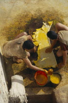 Chouwara Tanneries.  Looking down on two men dyeing stretched and prepared hide yellow.Fez