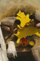 Chouwara Tanneries.  Looking down on two men with stretched yellow hide.Fez